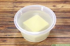 a plastic container filled with liquid on top of a wooden table