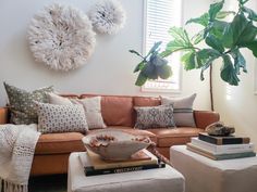 a living room filled with lots of furniture next to a potted plant on top of a table