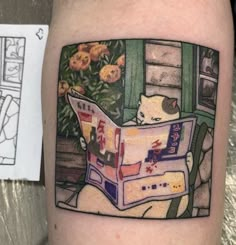 a person with a tattoo on their arm has a cat reading a book and flowers in the background