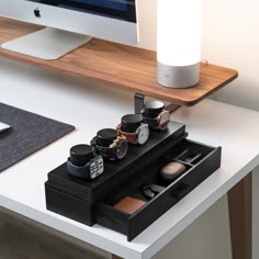 a desk with a computer, watch and other items on it