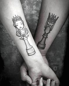 two people are holding hands with tattoos on their arms, one has a queen and the other is a knight