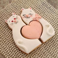 two decorated cookies in the shape of cats