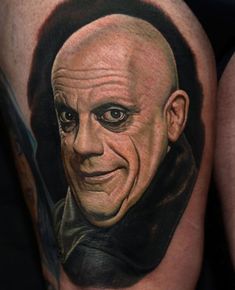 a close up of a person's leg with a tattoo on it that has an image of a man