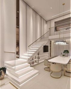 a white dining room with stairs leading up to the second floor