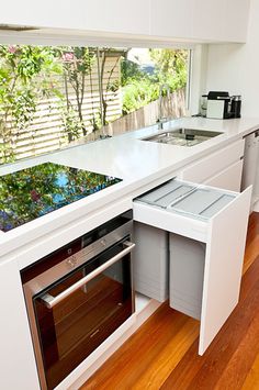 a kitchen with an oven, dishwasher and sink in the middle of it