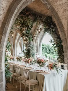 a long table is set up with flowers and greenery for an outdoor wedding reception