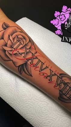 an arm with a rose and some letters on it