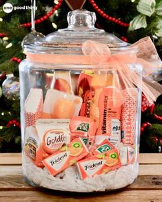 a glass jar filled with oranges and other items on top of a wooden table