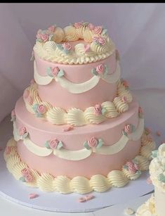 there is a three layer cake with pink and white frosting on the top tier