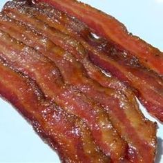 two pieces of bacon sitting on top of a white plate