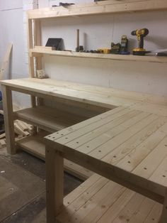 a workbench made out of wood with tools on the table and shelves behind it