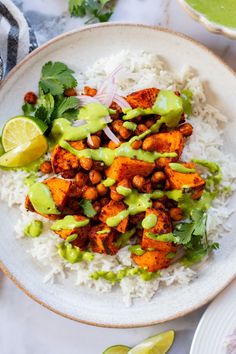 a white plate topped with rice and meat covered in avocado garnish