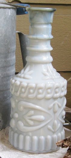 a white vase sitting on top of a table