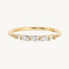 a yellow gold ring with three stones on the side and two diamonds in the middle