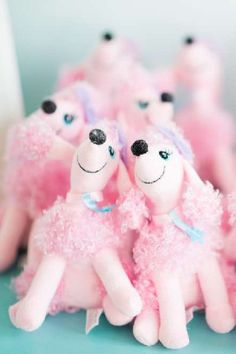 some pink stuffed animals sitting on top of a blue surface with black dots around them