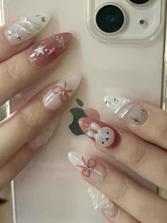 a woman with pink and white nail polish holding an apple phone in front of her