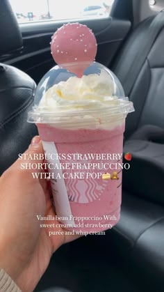 someone holding up a cup with whipped cream in it and the caption starbucks strawberry shortcake frappuccino