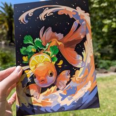 a hand holding up a card with an orange fish on it