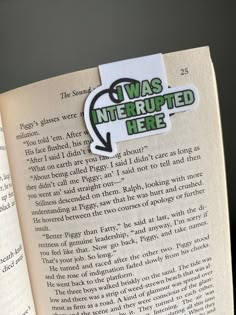 an open book with a green sticker on the page that says i was interrupted here