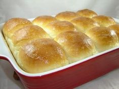 a red casserole dish filled with rolls