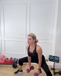 a woman squats on one leg while holding two dumbbells in front of her