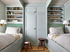 two twin beds in a bedroom with built - in bookshelves and storage units