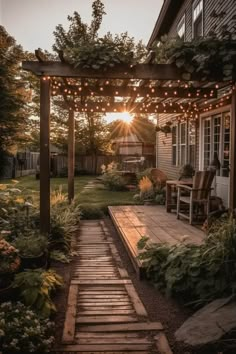 the sun is setting in the back yard with lights strung over it and wooden steps leading up to an outdoor seating area