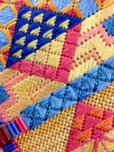 a close up view of a colorful piece of cloth with beading on the edges