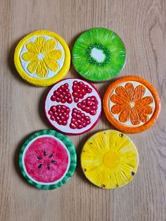 four paper plates with different designs on them sitting on top of a wooden table next to each other