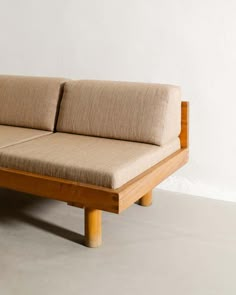 a wooden couch sitting on top of a white floor