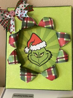 an origami christmas card with the grin face and santa hat on it's head