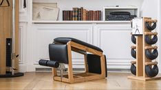 a wooden chair sitting on top of a hard wood floor next to a book shelf