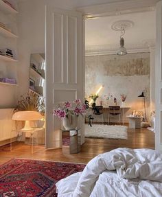 a bedroom with white walls and wooden floors