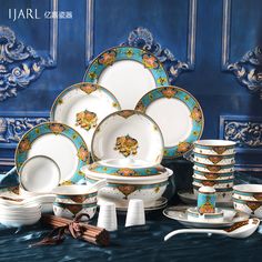 a table topped with lots of white and blue plates next to each other on top of a counter