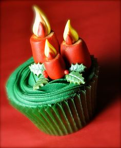 three red candles sitting on top of a green cupcake