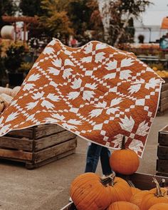 an orange and white quilted pumpkins in a crate at a farmer's market