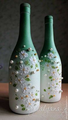 two green vases with flowers painted on them