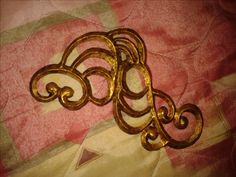 an ornate gold metal object sitting on top of a quilt