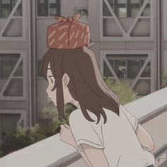 a woman with a hat on her head looking at something in front of some buildings