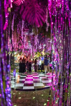 people are standing in the middle of a checkerboard floor with purple lights on it