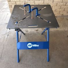 a table with tools on it sitting in front of a brick wall that says miller