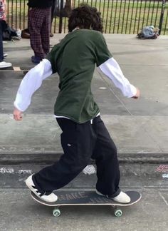 a young man riding a skateboard down a sidewalk