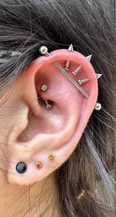 a woman with ear piercings that have spikes on their ears and are attached to the side of her ear