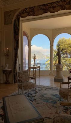 an ornate living room with large windows overlooking the ocean