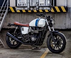 a white and blue motorcycle parked next to some stairs