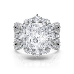 an engagement ring with a large cushion cut diamond surrounded by smaller round diamonds and pave - set shoulders