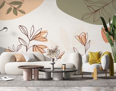 a living room with white couches and colorful wallpaper