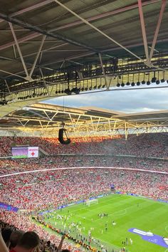 a large stadium filled with lots of people sitting on top of the stands watching a soccer game