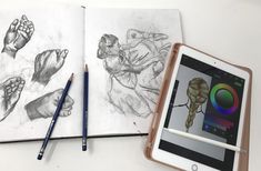 an ipad next to a drawing book with two hands and feet on the page,