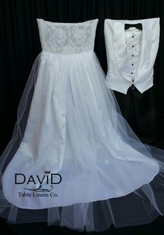 a wedding dress and tuxedo on display in front of a black backdrop with the name david written on it